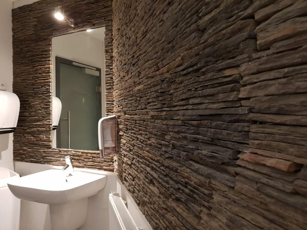 Natursteinwand in einem Gäste-WC.